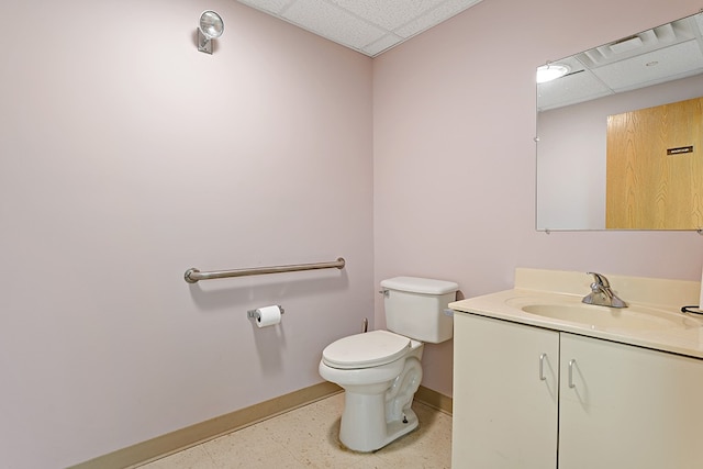 bathroom featuring vanity, a drop ceiling, and toilet