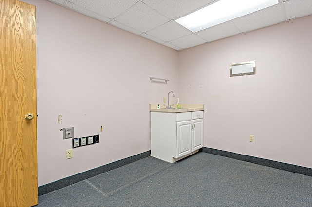 interior space with a paneled ceiling and sink