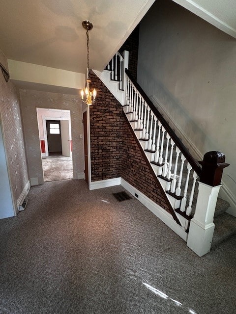 stairway featuring a notable chandelier, brick wall, carpet flooring, and a high ceiling