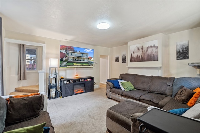 living area featuring a glass covered fireplace and carpet flooring