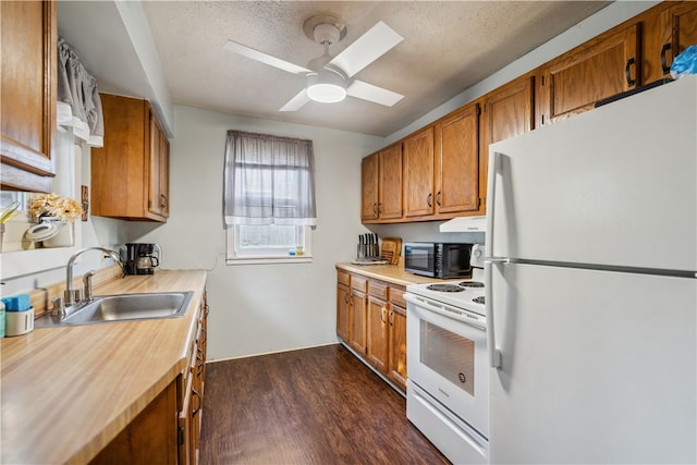 kitchen featuring light countertops, white appliances, brown cabinetry, and a sink