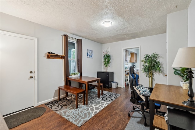 home office with baseboards, dark wood finished floors, and a textured ceiling