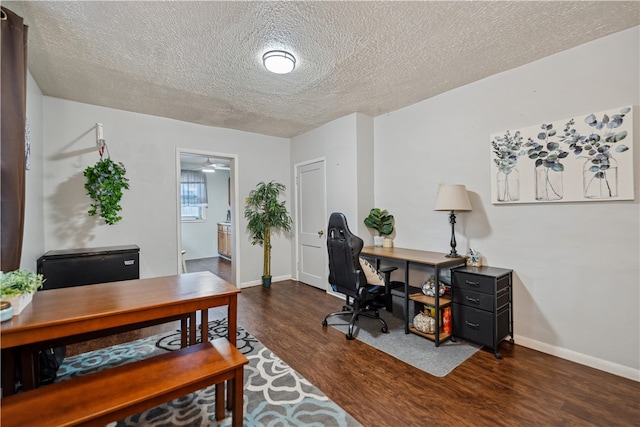 office space with dark wood-type flooring, a textured ceiling, and baseboards