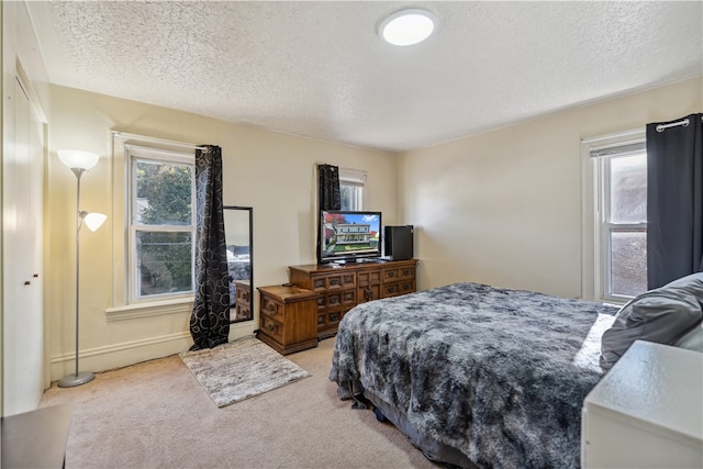 carpeted bedroom with multiple windows and a textured ceiling