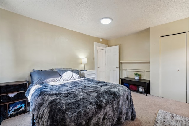 bedroom featuring carpet, a closet, and a textured ceiling