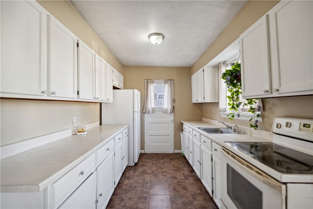 kitchen with white appliances, white cabinets, a sink, and light countertops