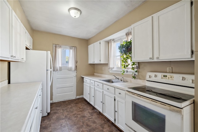 kitchen featuring white cabinets, white appliances, light countertops, and a sink