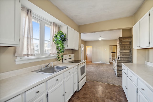 kitchen with light countertops, white cabinets, a sink, and electric range