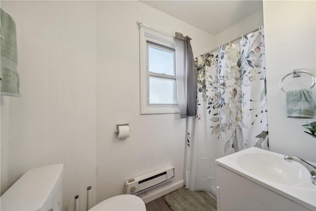 full bathroom with a baseboard heating unit, curtained shower, vanity, and toilet