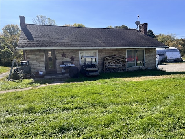 rear view of house featuring a lawn