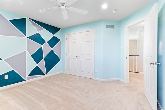 unfurnished bedroom with light colored carpet, a closet, and ceiling fan