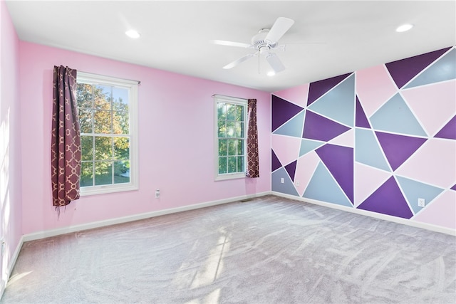 carpeted spare room featuring ceiling fan