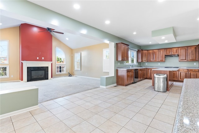 kitchen featuring dishwasher, light carpet, ceiling fan, lofted ceiling, and a premium fireplace