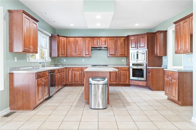 kitchen featuring appliances with stainless steel finishes, a center island, sink, and light tile patterned floors