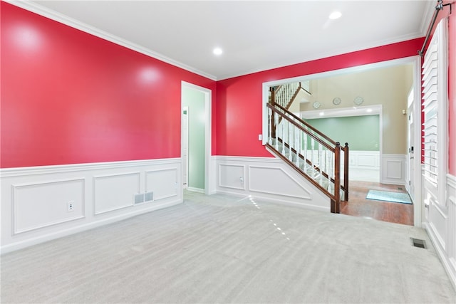 carpeted foyer featuring crown molding