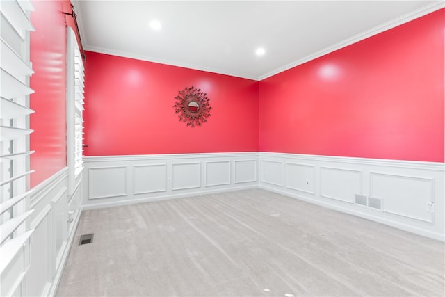 empty room featuring light carpet and crown molding