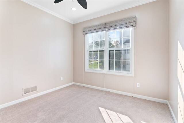 empty room featuring crown molding, light colored carpet, and ceiling fan