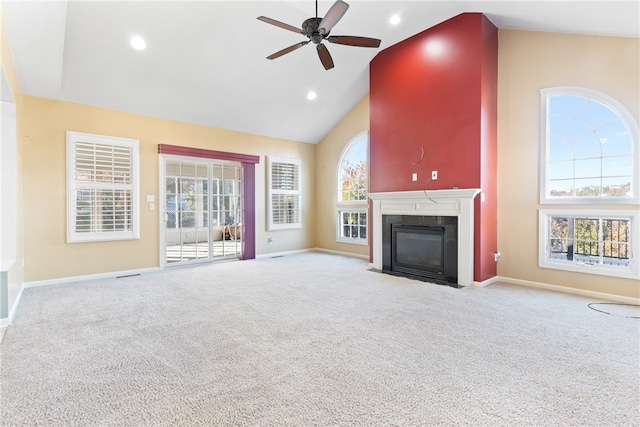 unfurnished living room with a premium fireplace, light colored carpet, high vaulted ceiling, and ceiling fan