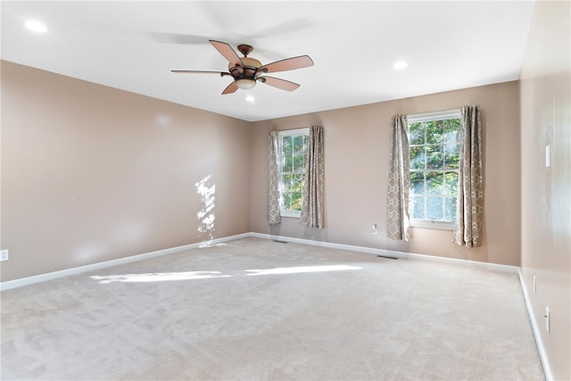 carpeted spare room with ceiling fan