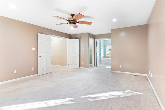 spare room with light colored carpet and ceiling fan