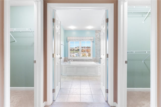 bathroom with a bath and tile patterned flooring