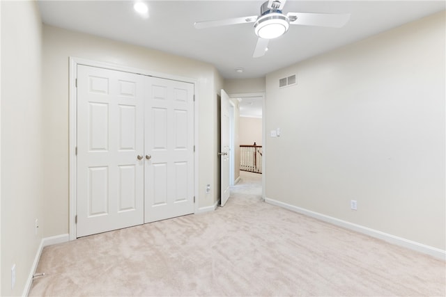 unfurnished bedroom featuring a closet, ceiling fan, and light colored carpet