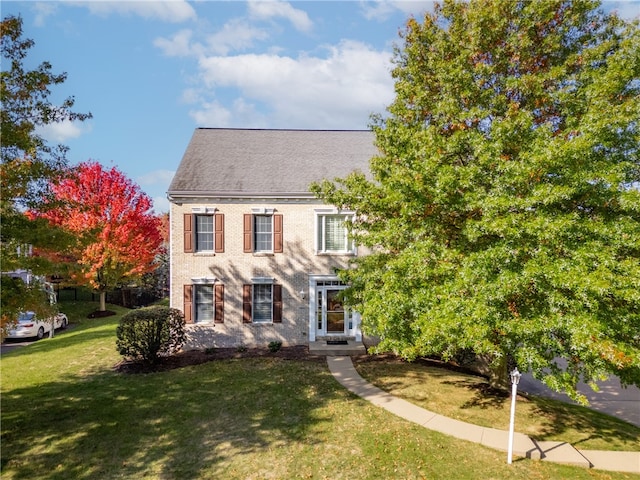 colonial inspired home with a front lawn