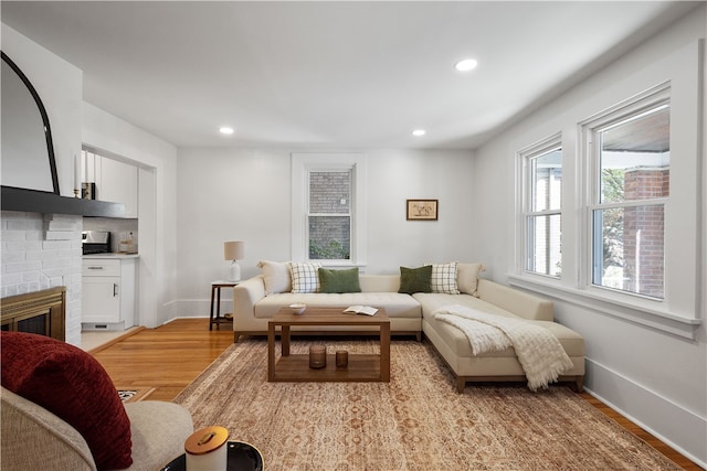 living room featuring light hardwood / wood-style floors and a brick fireplace