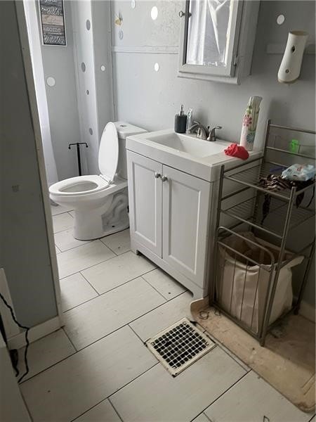 bathroom featuring vanity, toilet, and tile patterned flooring