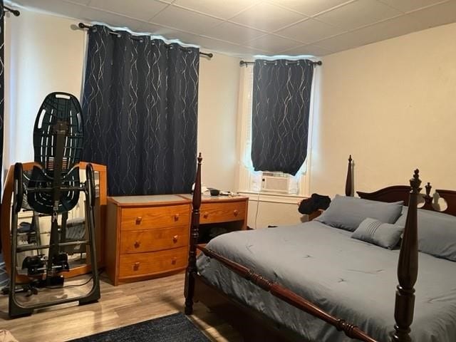 bedroom with cooling unit and light wood-type flooring