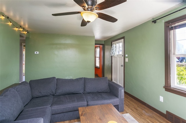 living room featuring ceiling fan, a healthy amount of sunlight, and wood-type flooring