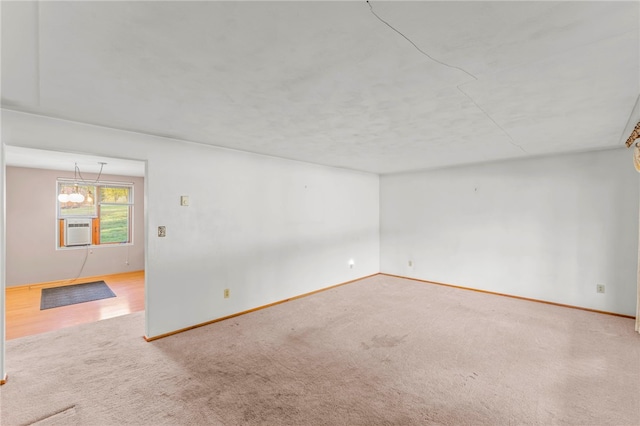 empty room with carpet, an inviting chandelier, and cooling unit