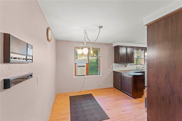 kitchen featuring a wealth of natural light, dark brown cabinets, and light wood-type flooring