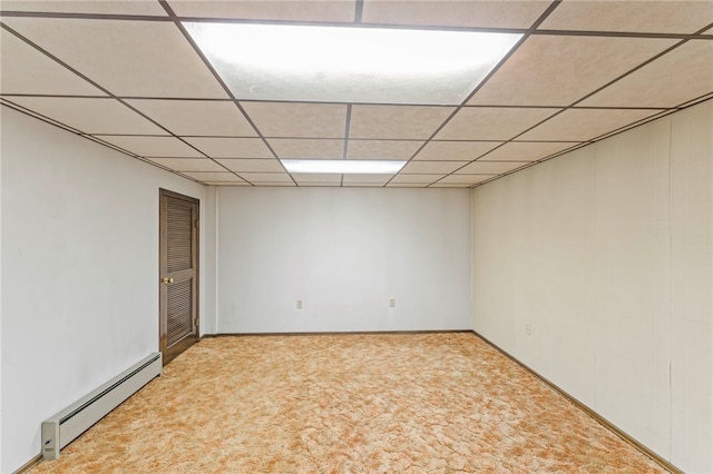 unfurnished room with a paneled ceiling, light colored carpet, and a baseboard radiator