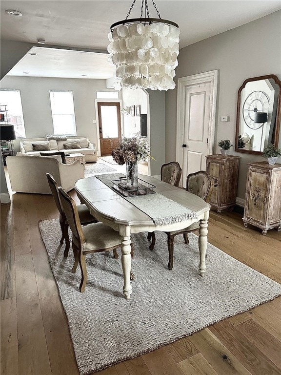 dining area featuring dark wood-type flooring and a notable chandelier