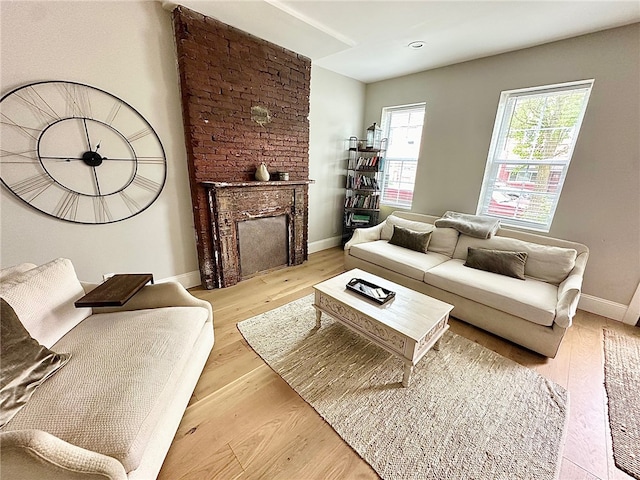 living room featuring light hardwood / wood-style floors and a large fireplace