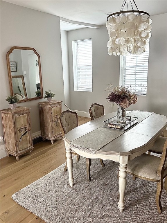 dining area featuring light hardwood / wood-style floors, an inviting chandelier, and a wealth of natural light