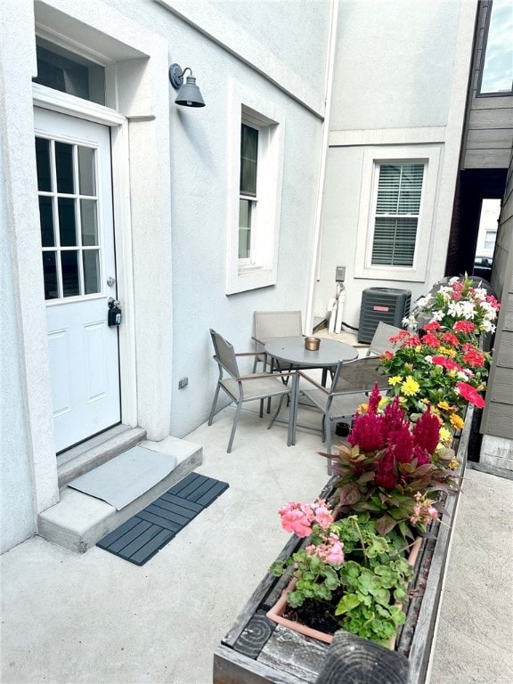 doorway to property with central air condition unit and a patio