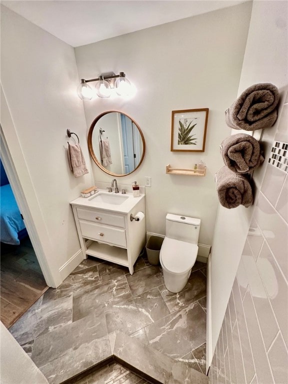 bathroom with vanity, toilet, and hardwood / wood-style flooring