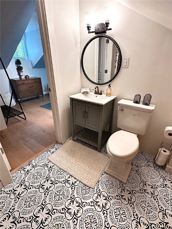 bathroom featuring vanity, toilet, lofted ceiling, and hardwood / wood-style floors