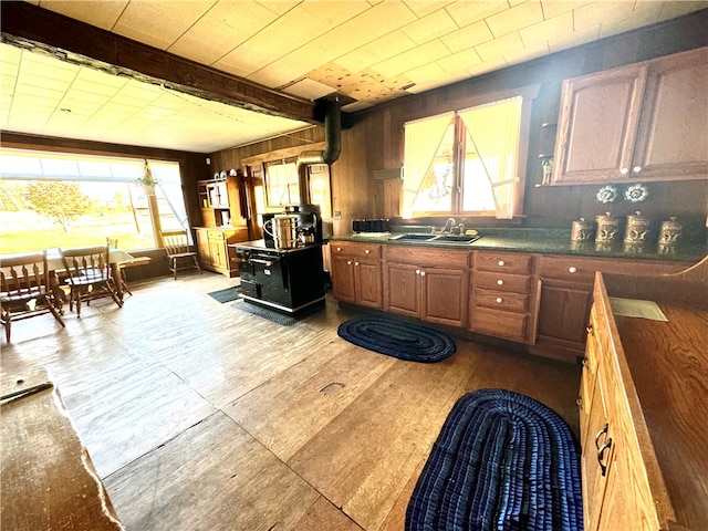 kitchen with wood walls, sink, and light wood-type flooring