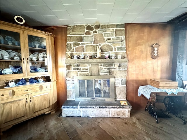 room details featuring hardwood / wood-style flooring, wooden walls, and a fireplace