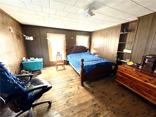 bedroom with hardwood / wood-style floors and wood walls