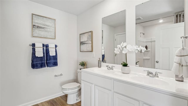 bathroom featuring hardwood / wood-style flooring, vanity, toilet, and a shower