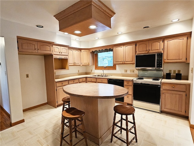 kitchen with black appliances, a kitchen island, sink, and a breakfast bar area