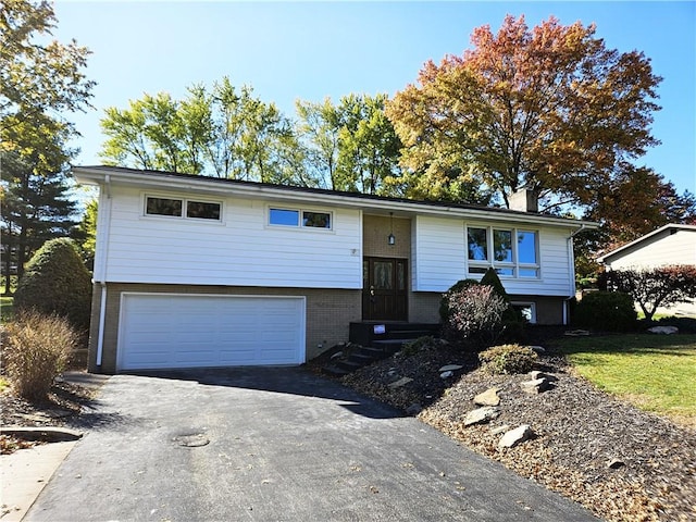 2656 Shelly Dr, White Twp Ind, PA 15701 - split foyer home with aphalt driveway, a chimney, brick siding, and a garage