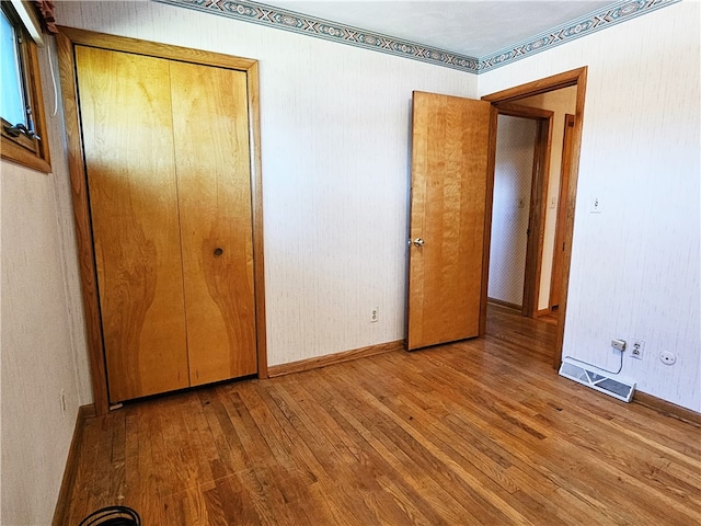 unfurnished bedroom featuring a closet and light wood-type flooring