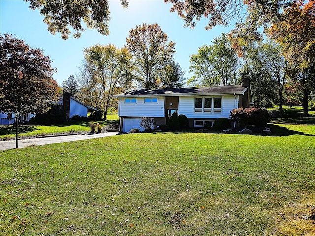 raised ranch with a front yard and a garage