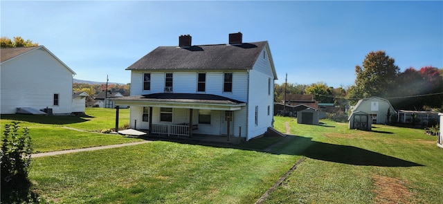 back of house with a yard, a shed, and a porch