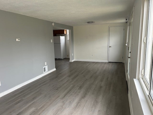 spare room with dark wood-type flooring and a textured ceiling